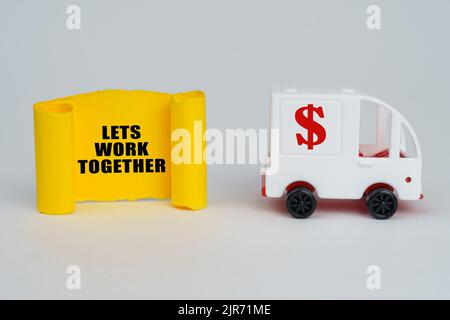 Geschäftskonzept. Auf einer weißen Oberfläche lassen sich eine Schreibmaschine und ein gelber Pappteller mit der Aufschrift - zusammen arbeiten Stockfoto