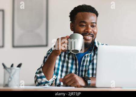 Schwarzer Mann Mit Kaffee Mit Laptop Online Arbeiten Im Büro Stockfoto