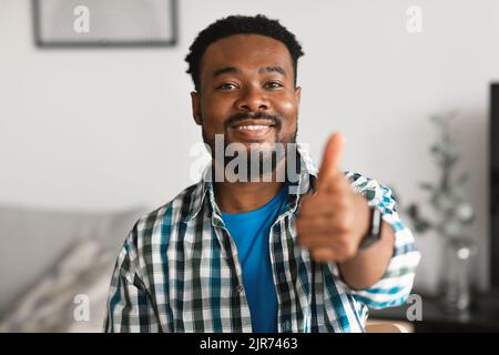 Schwarz Männlich Gestikulierend Daumen Nach Oben In Genehmigung Posiert Zu Hause Stockfoto