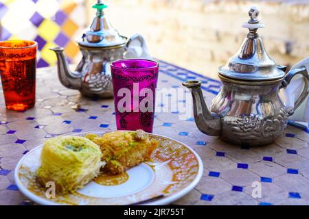 Minztee im marokkanischen Stil und Nahost-Süßigkeiten auf der Terrasse der El Bañuelo Teteria in Granada, Spanien Stockfoto