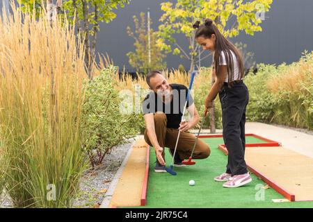 Vater und Tochter spielen Mini Golf Stockfoto