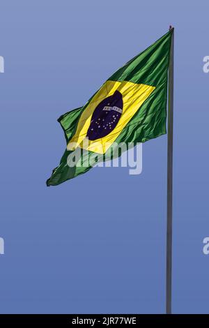 Goiânia, Goias, Brasilien – 22. August 2022: Brasilianische Flagge fliegt, flattert im Wind und der blaue Himmel im Hintergrund. Stockfoto