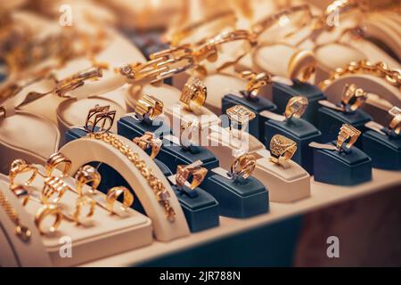 Goldene und silberne Ringe an einem Fenster eines Juwelierladens. Konzept der „Engage“-Feier Stockfoto