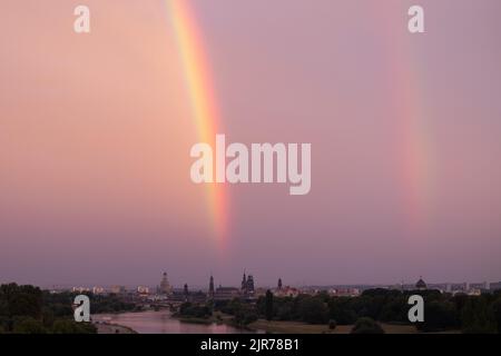 Dresden, Deutschland. 22. August 2022. Bei Sonnenuntergang über der Elbe und vor der Kulisse der Altstadt kann ein Regenbogen gesehen werden. Quelle: Sebastian Kahnert/dpa/Alamy Live News Stockfoto