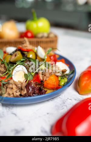 nicoise-Salat mit Thunfisch-Nahaufnahme auf dem Tisch mit Gemüse Stockfoto