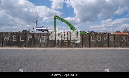 „Hilfe, ich brauche Liebe“ Mural an der Hafenmauer im Hafen von Great Yarmouth, Norfolk, England, Großbritannien. Stockfoto