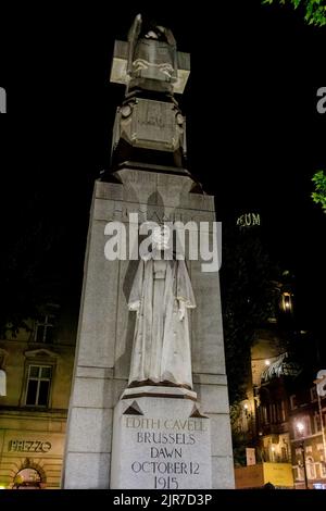 Das Edith Cavell Memorial, eine Statue von Sir George Frampton, die 1915 im Ersten Weltkrieg im West End von London WC2 bei Sonnenaufgang angeschossen wurde und nachts beleuchtet wurde Stockfoto