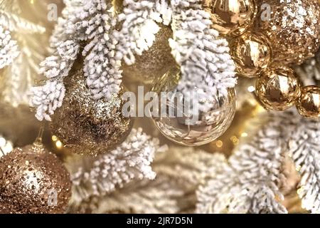 Wunderschön dekorierter und beleuchteter Weihnachtsbaum mit goldener Dekoration und Bokeh. Vintage-Tonung. Stockfoto