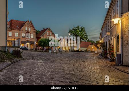 Der beleuchtete Platz in der kleinen dänischen Stadt Mariager während der blauen Stunde, Mariager, Dänemark, 5. August 2022 Stockfoto