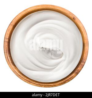 Saure Creme in Holzschüssel, Mayonnaise, Joghurt, isoliert auf weißem Hintergrund, Schnittpfad, volle Schärfentiefe Stockfoto