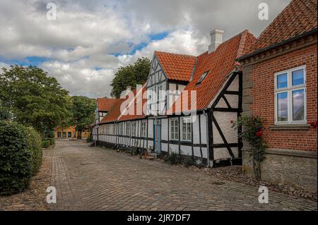 Weißes und schwarzes, malerisches Fachwerkhaus in einer gepflasterten Straße in der dansih-Stadt Mariager, Dänemark, 6. August 2022 Stockfoto