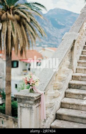 Blumenstrauß steht auf einer Marmorbalustrade in der Nähe der Treppe Stockfoto