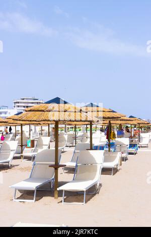 Traditionelle Strandliege und Sonnenschirm. Rimini, Italien, . Hochwertige Fotos Stockfoto