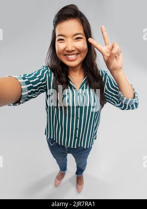 Gerne asiatische Frau unter selfie und Frieden Stockfoto