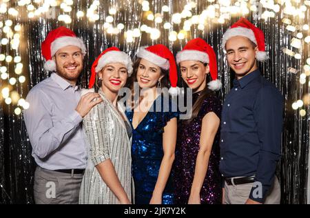 Gerne Freunde in santa Hüte auf Weihnachtsfeier Stockfoto