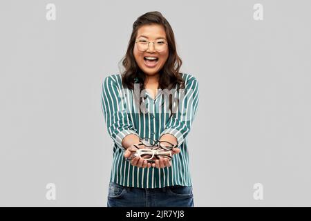 Glücklich lächelnde asiatische Frau in Brille oder Student Stockfoto