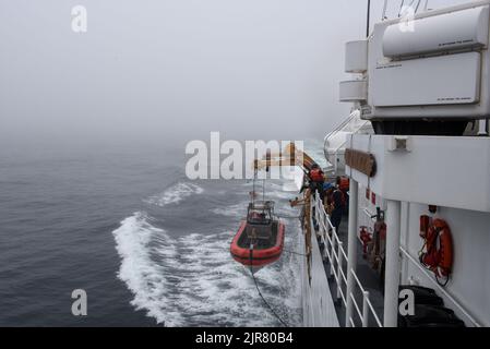 Besatzungsmitglieder, die dem USCGC Mohawk (WMEC 913) zugewiesen wurden, sichern das Over the Horizon (OTH)-Cutter-Boot für Hubschrauberoperationen während des Flugs im Atlantischen Ozean am 17. August 2022 auf Schiene. Mohawk befindet sich im geplanten Einsatzgebiet der US Naval Forces Africa, das von der Sechsten Flotte der USA eingesetzt wird, um die Interessen der USA, der Alliierten und der Partner zu verteidigen. (USA Foto der Küstenwache von Petty Officer, Klasse 3., Jessica Fontenette) Stockfoto