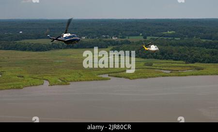 UH-1N Huey Heliopter, die der ersten Helicopter Squadron, Joint Base Andrews, MD., zugewiesen wurden, fliegen während des Trainings am 10. August 2022 über den Patuxent River, MD. 1 die Mission von HS besteht darin, eine vorrangige Luftbrücke für hochrangige zivile und militärische Führungskräfte auf nationaler Ebene in der Region der Hauptstadt zu schaffen. (USA Luftwaffe Foto von Master Sgt. Nicholikpriester) Stockfoto