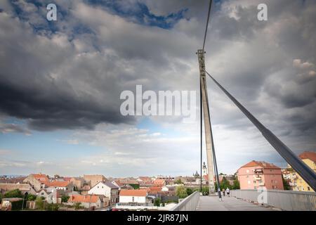 Bild einer Hängebrücke in der Stadt Sremska Mitrovica, im Norden Serbiens, die den Fluss Sava überquert, mit dem Stadtzentrum der Stadt in Srem Stockfoto