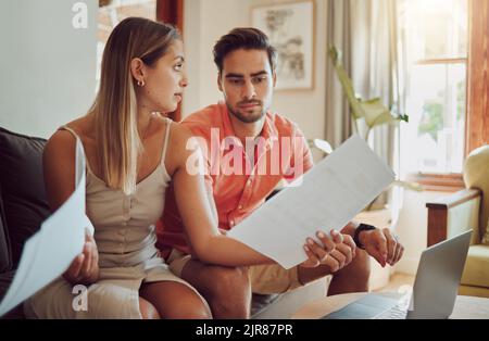 Unglücklich, gestresst und verärgert Paar zahlt Rechnungen oder Schulden online auf mit einem Laptop zu Hause immer wütend, Planung Budget. Junger Mann und Frau mit einem Stockfoto