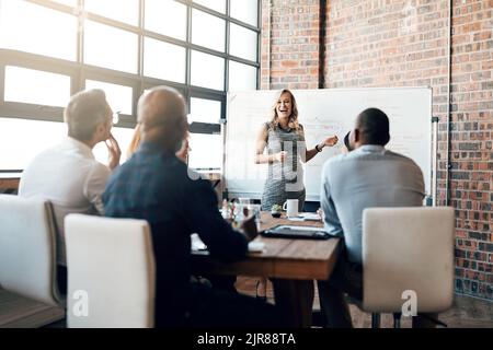 Eine Übergabe mit ihrem Team vor dem Mutterschaftsurlaub. Eine Schwangere Geschäftsfrau, die im Sitzungssaal einen Vortrag gehalten hat. Stockfoto