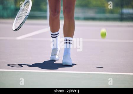 Fitness, Tennis und Sport Beine der Frau mit Schläger und Ball zu Fuß auf dem Platz nach dem Servieren in Training, Training oder Bewegung. Sportliche Schuhe, aktiv oder Stockfoto
