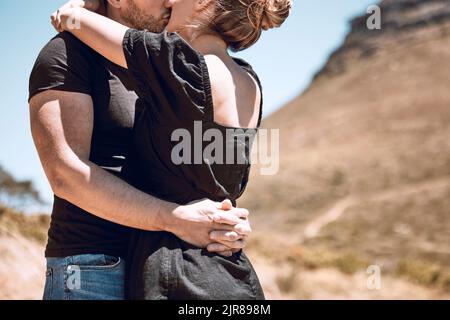 Küssen, umarmen und umarmen Paar sich verliebt, romantisch oder zufrieden, während sie draußen dicht beieinander stehen. Mann und Frau verbinden sich, genießen die Zeit Stockfoto