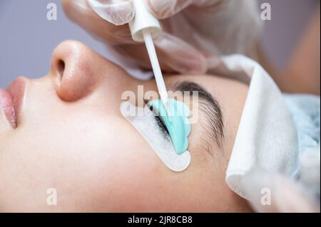 Junge Frau, die Wimpern färbt und laminiert. Stockfoto