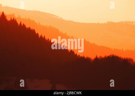 Die Silhouetten der Waldberge in der goldenen Stunde - Sonnenuntergang Stockfoto