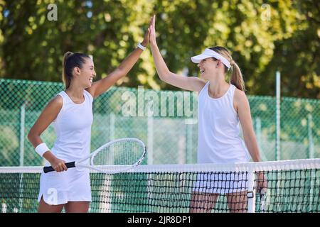 High Five, Erfolg und feiern zwischen Frauen Tennisspielerinnen Training im Freien auf dem Platz. Glückliche, siegreiche und fund Athleten oder Freunde spielen in Stockfoto