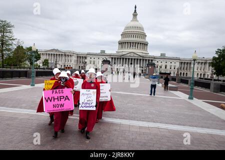 Demonstranten, die als Dienstmädchen aus der Geschichte der Dienstmädchen gekleidet sind, verlassen die Route des Kapitols zum Obersten Gerichtshof. Die Handmaids Army DC kam nach Capitol Hill, um gegen die durchgesickerte vorläufige Entscheidung des Obersten Gerichtshofs zu protestieren, Roe v. Wade umzustürzen. Stockfoto