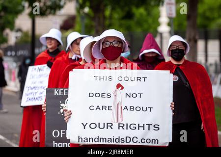 Washington, USA. 8.. Mai 2022. Demonstranten, die als Dienstmädchen aus der Geschichte der Dienstmädchen gekleidet sind, gehen während der Kundgebung vor den Obersten Gerichtshof. Die Handmaids Army DC kam nach Capitol Hill, um gegen die durchgesickerte vorläufige Entscheidung des Obersten Gerichtshofs zu protestieren, Roe v. Wade umzustürzen. (Bild: © Allison Bailey/SOPA Images via ZUMA Press Wire) Stockfoto