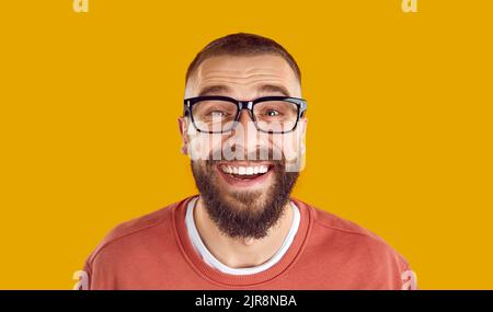 Kopfschuss eines fröhlichen, lustigen bärtigen Mannes in einer Brille, der lächelnd und lachend auf die Kamera schaute Stockfoto