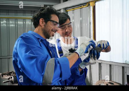 Arbeiter wechseln und reparieren Teile der Räder beim Autoservice Stockfoto