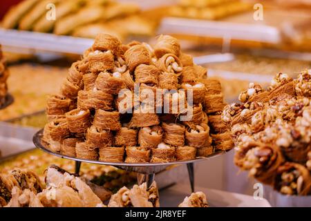 Kadayif traditionelle Ottomane und arabisches Dessert mit Zuckernudeln und Nüssen Füllung. Gebäck und türkische Baklava zum Verkauf Stockfoto