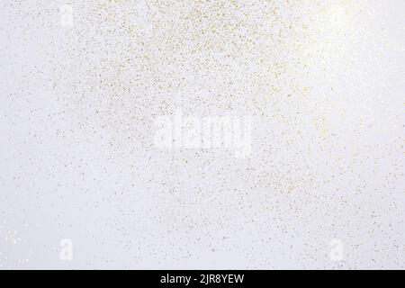 Gold Glitzer auf weißem Hintergrund gestreut. Festlicher Hintergrund. Stockfoto