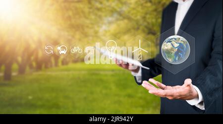 Umweltkonzept Business man halten und zeigen global mit Öko-Symbol. Business man mit Tablet zum Umweltschutz Industrie zu analysieren Environm Stockfoto