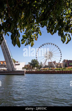 Danzig, Polen - 9. September 2020: Die Zugbrücke über den Fluss Motława und das Riesenrad auf der Insel Olowianka in Danzig Stockfoto