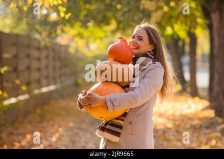 Porträt einer glücklichen Frau mit Kürbissen in der Hand. Stockfoto