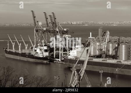 ODESSA, UKRAINE-27. NOVEMBER 2021: Odessa Handelshafen in Friedenszeiten 4 Monate vor Kriegsbeginn mit Russland. Schiffskräne, Lagerhäuser, Tanker Stockfoto