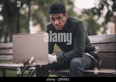Mann, der Karton hält und auf die Kamera schaut Stockfoto