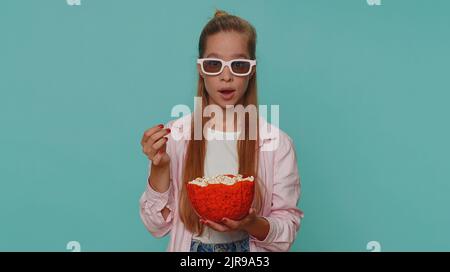 Aufgeregt Teenager Mädchen essen Popcorn und sehen interessante tv-Serie, Sportspiel-Film, Online-Social-Media-Film-Inhalte online. Schüler Kind Kind auf blauem Hintergrund genießen häusliche Unterhaltung Stockfoto