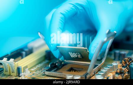 Elektronikingenieur, der Computerchip auf die Buchse legt. Chipsatz auf der elektronischen Leiterplatte der PC-Hauptplatine. CPU-Chip. Elektronische Komponenten. Stockfoto