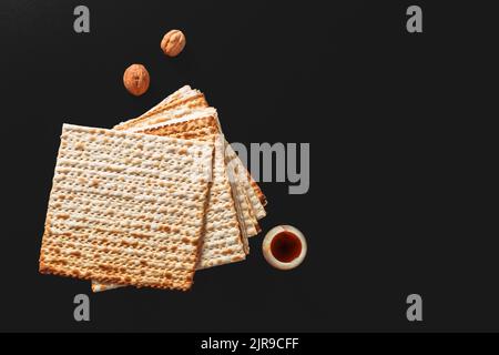 Ein Foto von Matza oder Matza-Stücken auf schwarzem Hintergrund. Matza für die jüdischen Passahfeiertage. Platz für Text, Platz zum Kopieren Stockfoto