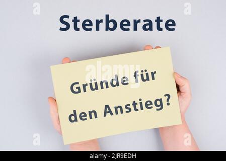 Die deutschen Worte für die Sterblichkeitsrate, die Gründe für den Anstieg stehen auf dem Papier, covid-19 pandemische Todesfälle, Impfschäden Stockfoto
