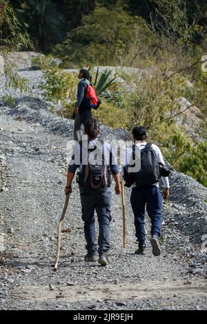 Januar 1. 2020 Uttarakhand INDIEN. Wanderer mit Rucksäcken und Stöcken steigen auf einem bergauf Pfad. Stockfoto