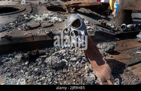 Überreste der Gasmaske eines Soldaten. Ein Fragment eines rostigen ausgebrannten Autos Russlands. APC. Ausstellung der zerstörten verbrannten russischen Militärausrüstung auf Chreschatyk. Stockfoto