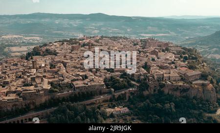 Blick von oben auf die italienische Stadt Gubbio, die an einem Sommertag auf einem Hügel erbaut wurde Stockfoto