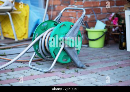 Gartenschlauchtrommel auf einem Bürgersteig. Hochwertige Fotos Stockfoto