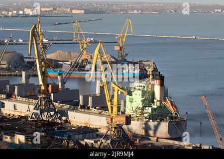 ODESSA, UKRAINE-27. NOVEMBER 2021: Odessa Handelshafen in Friedenszeiten 4 Monate vor Kriegsbeginn mit Russland. Schiffskräne, Lagerhäuser, Tanker Stockfoto